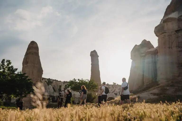 group of people hiking through fairy chimneys in Cappadocia at sunset