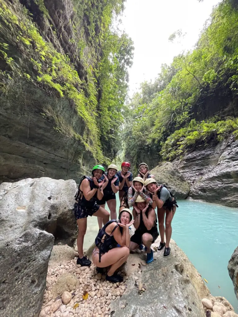 group of friends canyoning in a lush green gorge