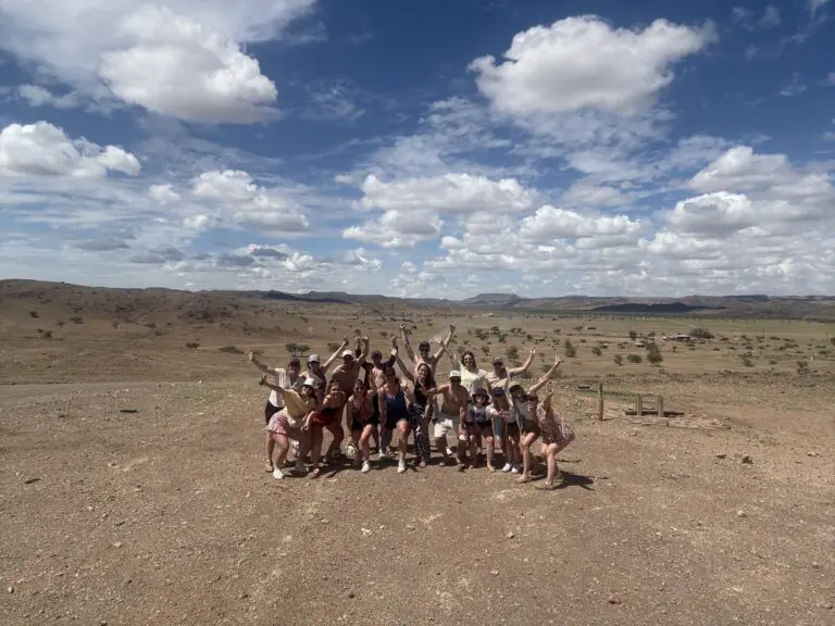 group of friends posing in vast Namibian desert landscape