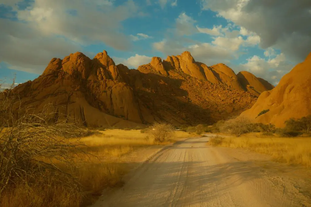dirt road leading to Spitzkoppe mountains in Namibia at sunset