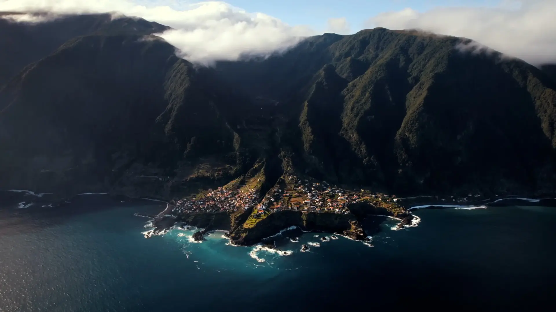 aerial view of coastal village nestled in mountains, Madeira