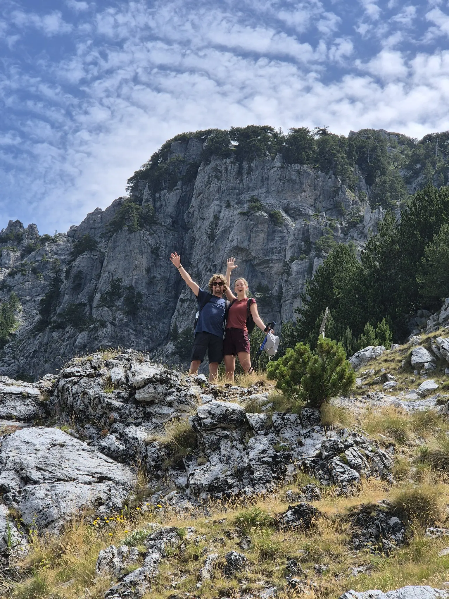 two hikers celebrating on a rocky mountain trail
