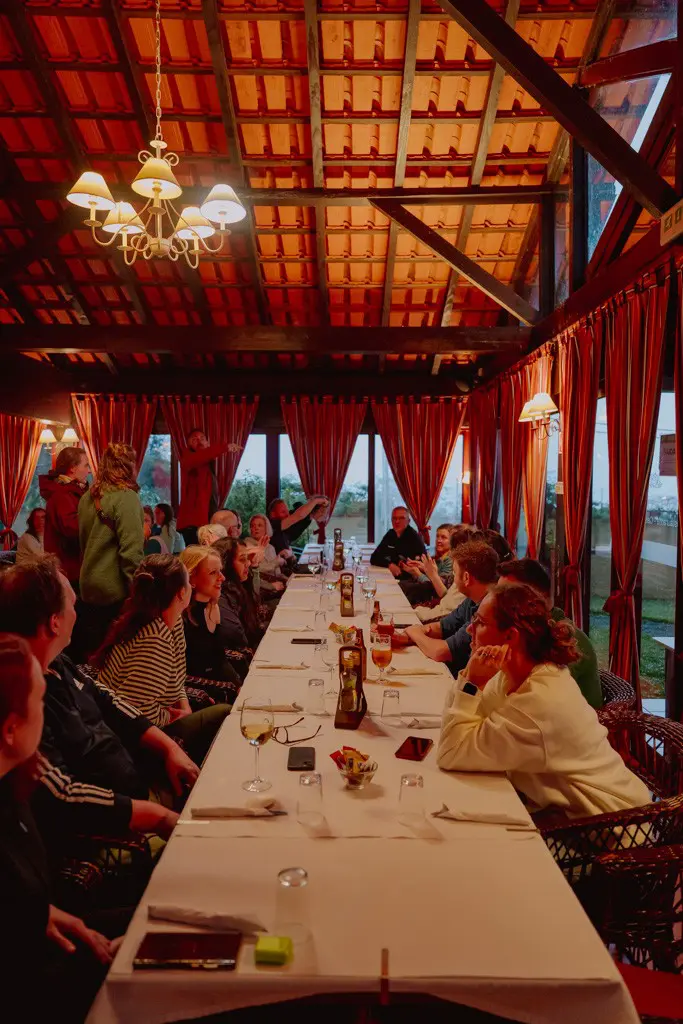 group of people dining at a long table in a rustic restaurant