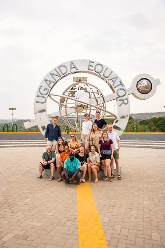 group of people posing at the Uganda Equator monument