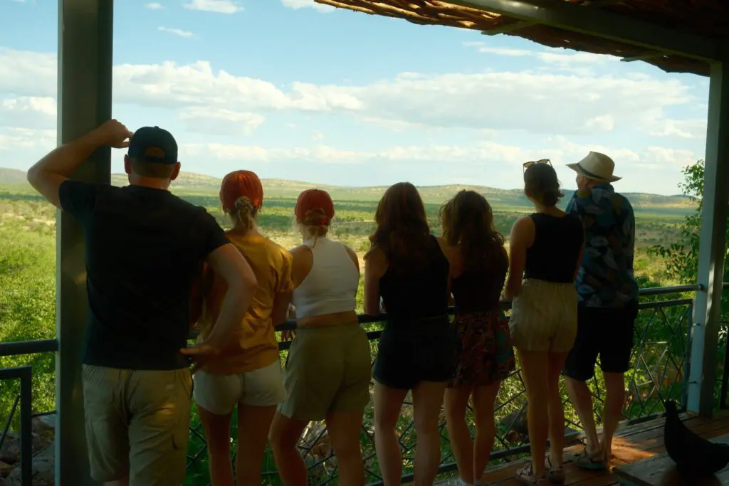 group of friends enjoying a panoramic view from a lodge balcony in Namibia