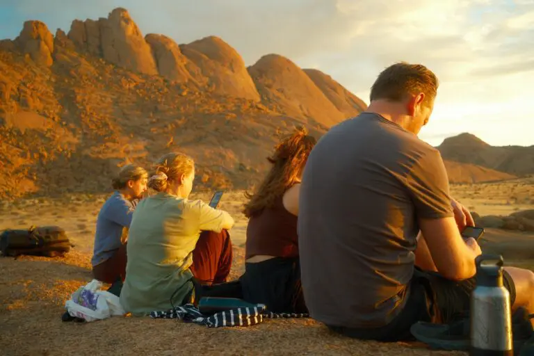group of friends watching sunset over desert mountains in Namibia