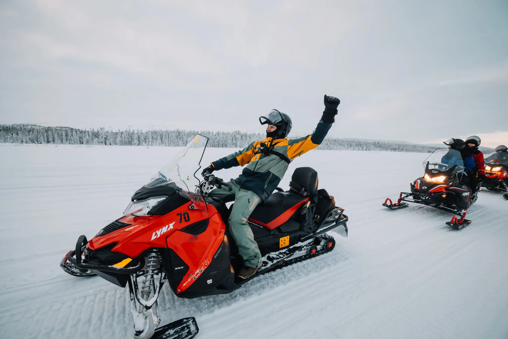 person cheering on a snowmobile in snowy Lapland landscape