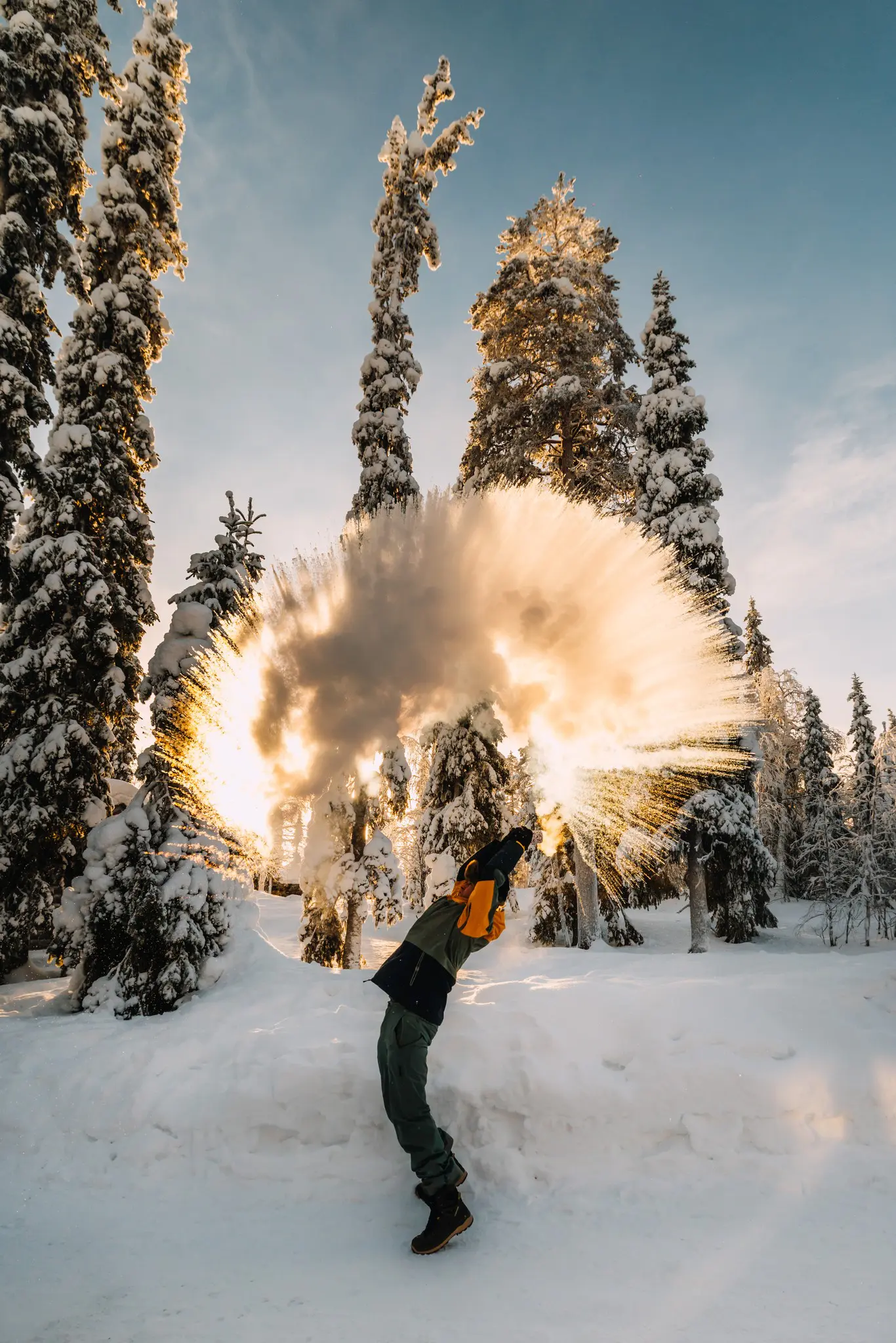person throwing hot water into cold air in snowy forest