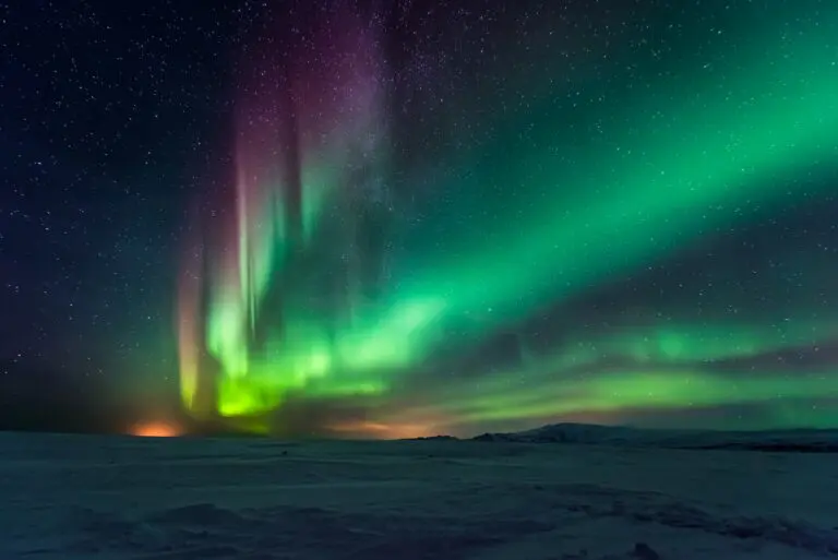 vibrant aurora borealis over a snowy landscape at night